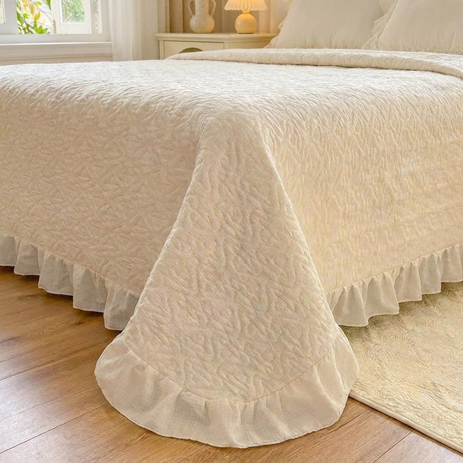 Détail du volant froncé et du matelassage en cœurs du couvre-lit crème