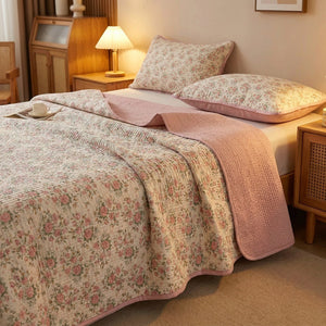 Couvre-lit matelassé imprimé floral rose dans une chambre chaleureuse avec lampe de chevet allumée