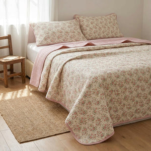 Couvre-lit matelassé imprimé floral rose dans une chambre romantique avec chaise en bois