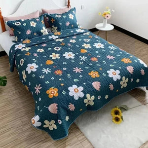 Couvre-lit matelassé bleu nuit à marguerites colorées installé sur un lit