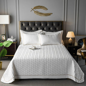 Couvre-lit matelassé blanc avec deux taies assorties sur un lit