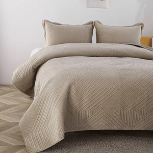 Détail de l'angle et du motif géométrique piqué du couvre-lit velours beige