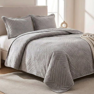 Couvre-lit matelassé velours gris avec taies assorties sur un lit