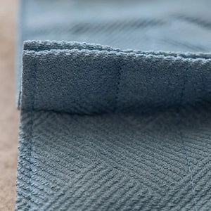 Gros plan sur le tissage chevron du rideau occultant coloris bleu