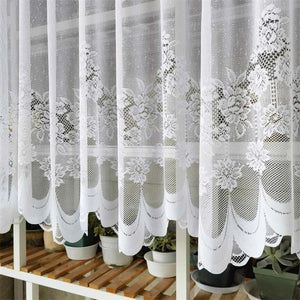 Detail rapproche du motif floral en dentelle du rideau