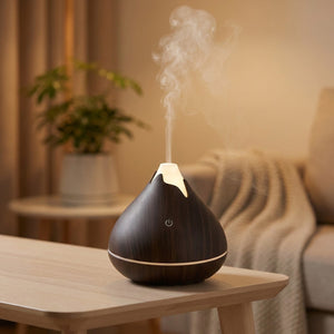 Diffuseur d'huiles essentielles ultrasonique en grain de bois foncé diffusant une brume dans un salon
