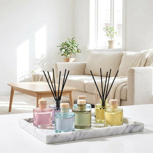 Collection diffuseurs à bâtonnets 50 ml, plusieurs parfums sur plateau marbre