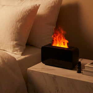 Diffuseur flamme LED sur table de chevet marbre dans chambre cosy