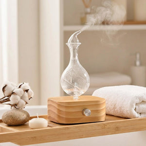 Diffuseur nébuliseur bois verre dans ambiance spa avec coton et pierres naturelles