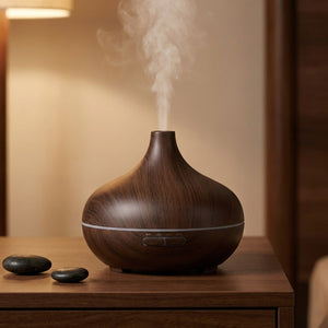 Diffuseur d'arômes grain de bois foncé espresso sur meuble bois avec galets noirs, ambiance zen