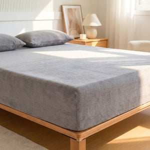 Drap-housse en flanelle gris ultra doux installé sur un matelas dans une chambre lumineuse