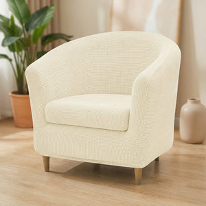 Housse de fauteuil club en jacquard écru installée sur un fauteuil arrondi dans un salon lumineux