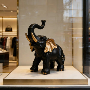 Sculpture éléphant porte-bonheur noir et or dans vitrine luxueuse
