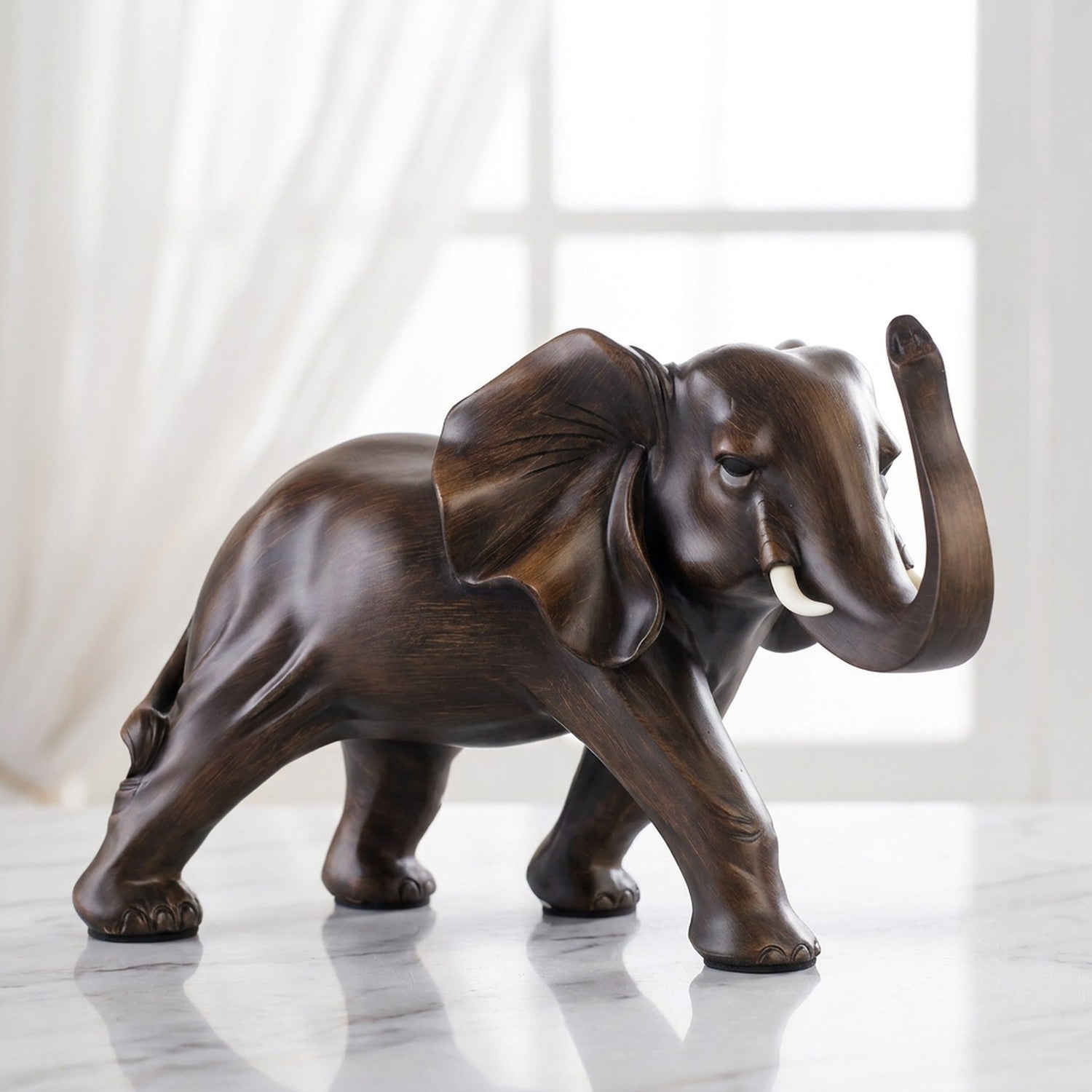 Sculpture d'éléphant en résine imitation bois sur surface en marbre près d'une fenêtre avec voilage