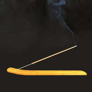 Bâton d'encens Palo Santo allumé sur support en bois fond sombre atmosphérique