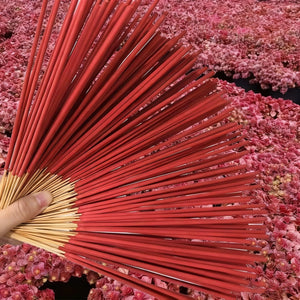 Bâtonnets d'encens sang de dragon rouge éventail ouvert sur fond de fleurs roses séchées