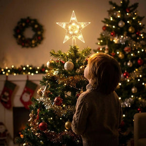 Enfant regardant l étoile lumineuse au sommet du sapin de Noël