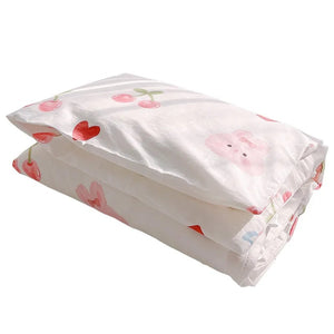 Parure de lit bébé motif lapin cerise pliée sur fond blanc