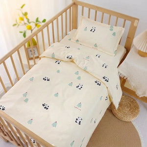 Parure de lit bébé au motif panda et sapins vert menthe installée sur un lit à barreaux
