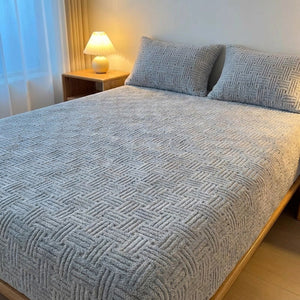 Drap-housse gris en peluche gaufrée dans une chambre moderne avec table de chevet