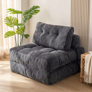 Chaise pliante convertible grise en velours côtelé dans un salon