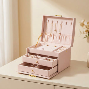 Boîte à bijoux à trois niveaux en simili cuir rose ouverte avec serrure dorée
