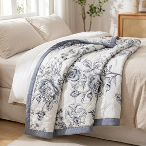 Couette d'été en coton lavé à roses noires pliée sur un lit