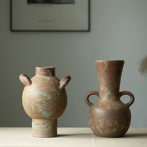 Deux vases grecs rustiques en céramique posés côte à côte sur une table en bois