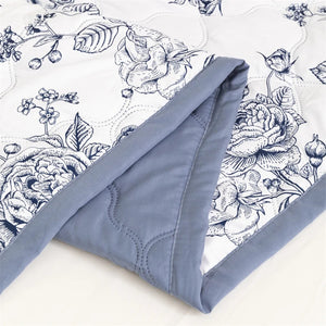 Détail du motif floral bleuté et du revers bleu de la couette d'été matelassée