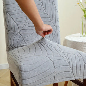 Installation de la housse de chaise grise sur une chaise près d'une table