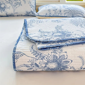 Couvre-lit plié montrant le motif fleuri bleu et les taies assorties