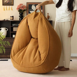 Fauteuil pouf doré porté par une personne grâce à sa poignée intégrée