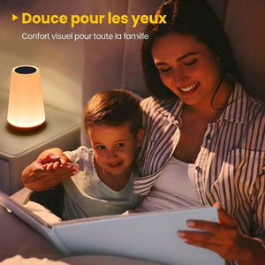 Mère et enfant lisant le soir avec la lampe tactile allumée sur la table de chevet