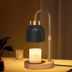 Lampe chauffe-bougie noire au bras doré diffusant une lumière chaude