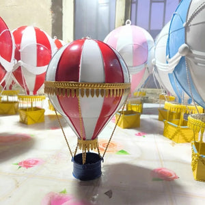 Ballons à air chaud 15cm en métal forgé exposés dans un atelier avec ballons suspendus