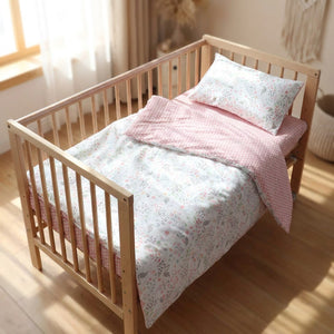 Parure de lit bébé cygne rose dans un petit lit en bois chambre lumineuse