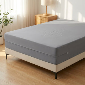 Protège-matelas imperméable gris installé sur un lit