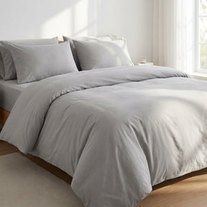 Parure de lit en coton lavé gris clair sur un lit dans une chambre moderne