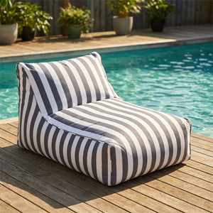 Pouf géant flottant à rayures gris posé au bord d'une piscine