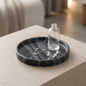 Plateau décoratif rond en marbre gris veiné avec bijoux et collier