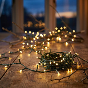 Guirlande lumineuse LED blanc chaud allumée enroulée sur une table en bois au crépuscule