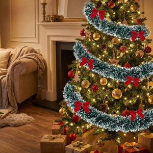 Guirlande tinsel givrée avec nœuds rouges spiralant autour d un sapin de Noël