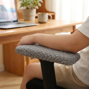 Bras posé sur l'accoudoir d'une chaise de bureau habillé d'une housse jacquard grise