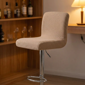 Tabouret de bar avec housse beige dans un coin bar chaleureux aux étagères en bois
