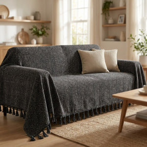 Housse de canapé en chenille noire à franges drapée sur un canapé