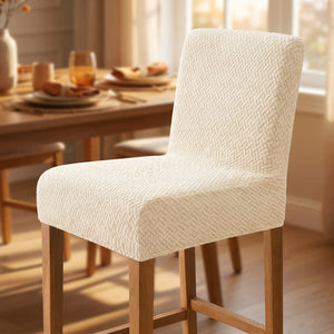 Housse de chaise de bar en jacquard beige vue de trois quarts dans une salle à manger cosy
