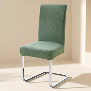 Housse de chaise extensible en maille jacquard Vert sauge sur une chaise de salle à manger