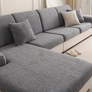 Canapé d'angle gris avec coussins habillés de housses en jacquard texturé