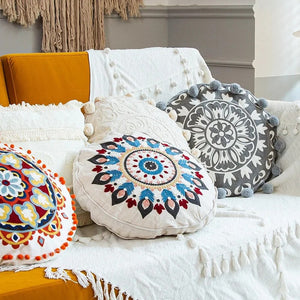 Housses de coussin mandala brodées disposées sur un canapé cocooning