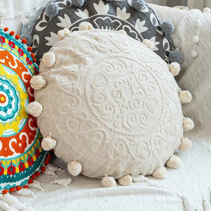 Housse de coussin ronde ivoire à motifs filigranes brodés avec pompons